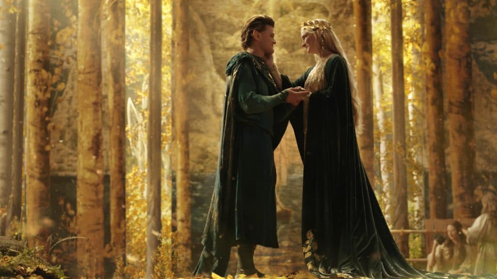 los elfos Elrond y Galadriel se miran sonriendo en un bosque