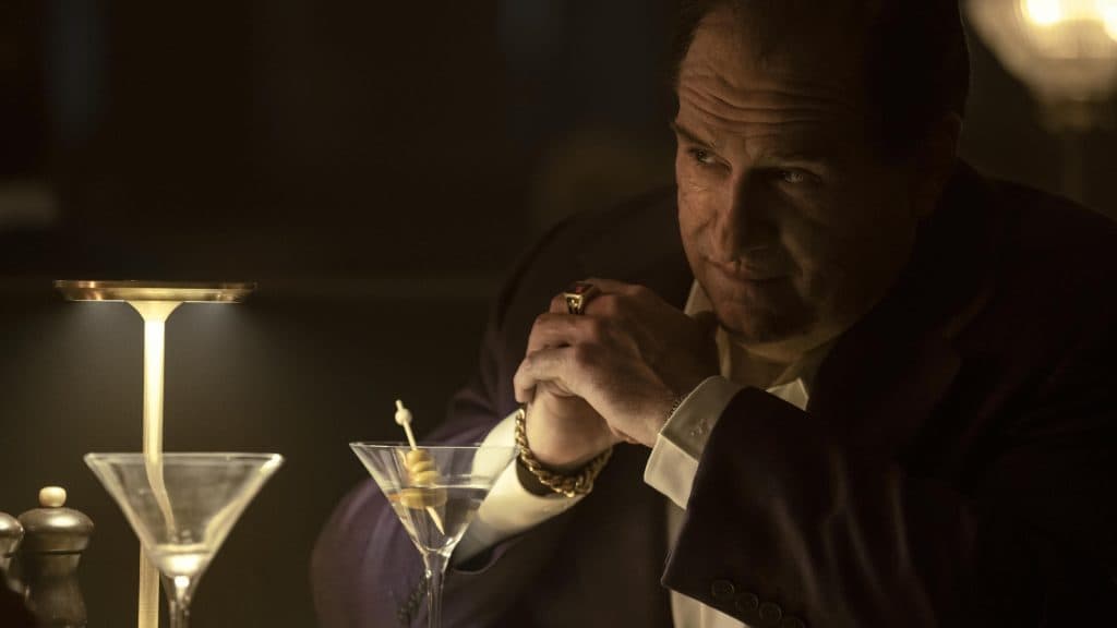 El Pingüino: Explicación del episodio 2 - un doctor sospechoso y una operación fallida 6 un homme en costume se tient à une table devant des verres à cocktail vides