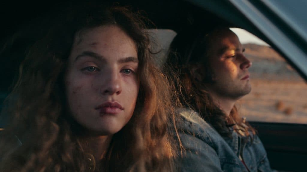 Amy alias Monique Hoyt con el rostro magullado mirando por la ventana del coche de Rodney Alcala en Une Femme en jeu