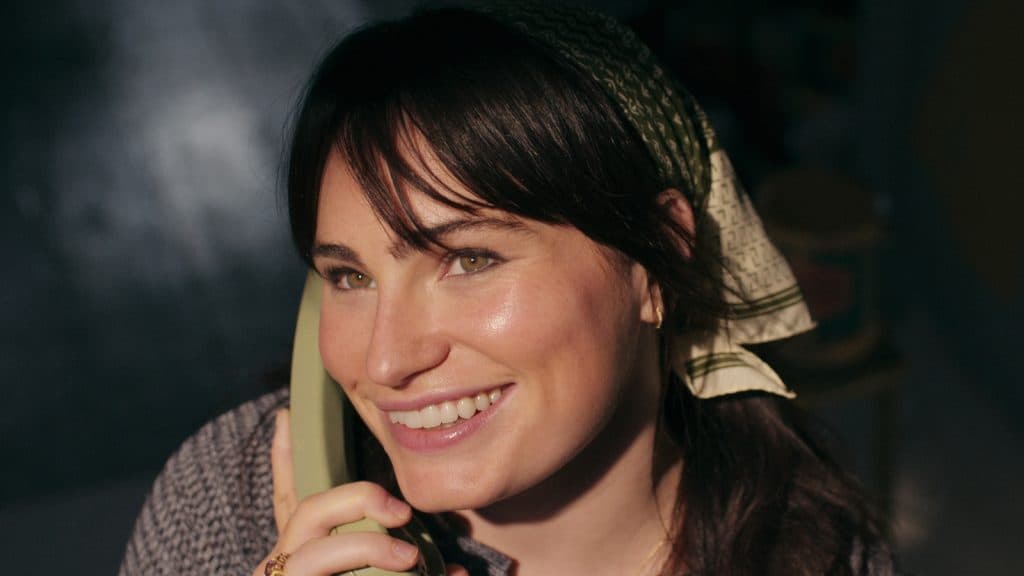 Charlie hablando por teléfono y sonriente en Une Femme en jeu