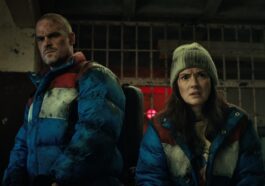 un homme (jim hopper) se tient derrière une jeune fille aux cheveux courts (eleven) dans stranger things