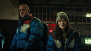 un homme (jim hopper) se tient derrière une jeune fille aux cheveux courts (eleven) dans stranger things