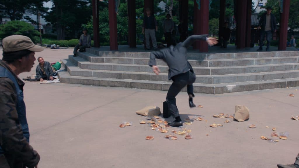 El vendedor aplastando pasteles en un lugar público en Squid Game